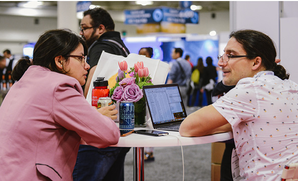 People sitting at a table connecting at an ASM meeting.